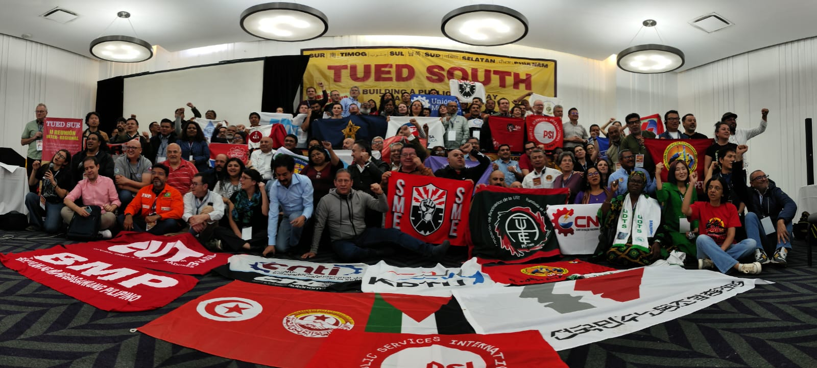 TUED South group photo — unions from around the world gathered with banners and flags at the previous Inter-Regional Meeting